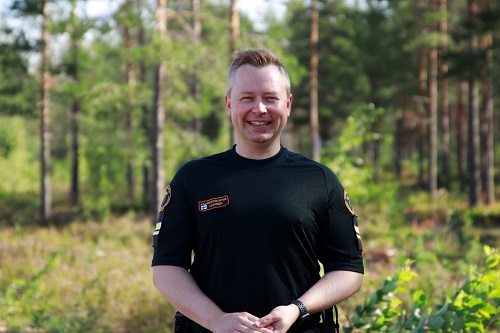 Majuri Jouni Lahtinen hymyilee luonnon keskellä.